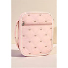 Pink quilted bag with bow patterns on a beige background