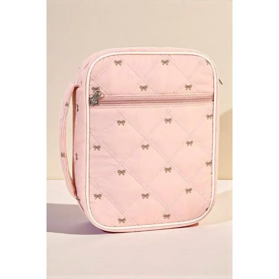 Pink quilted bag with bow patterns on a beige background